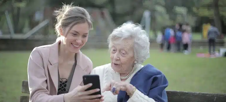 A person encouraging their grandparent to leave a review, which is one of the strategies for tailoring your services for the senior moving market