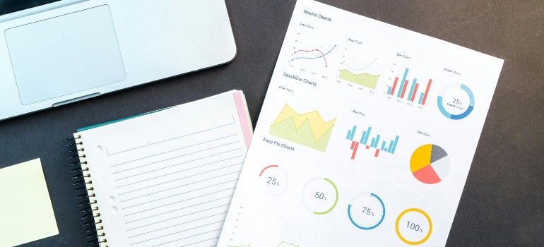 Performance charts and planning notebook on a desk, showing how to use data insights to grow your moving company.