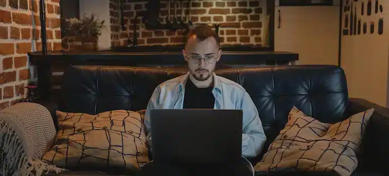 A person focused on his laptop, researching how to generate leads for a moving company