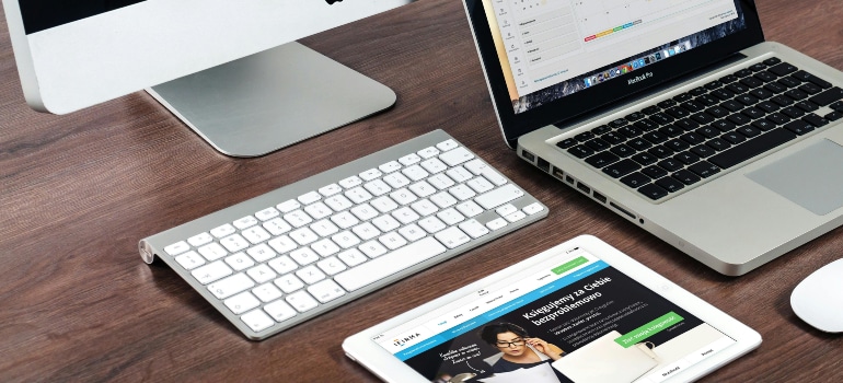 Multiple Apple devices showing a responsive website layout, illustrating the pros and cons of redesigning your website for multi-device compatibility.