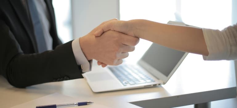 A man and woman shaking hands, symbolizing partnerships for cross-promotions in response to the DST.