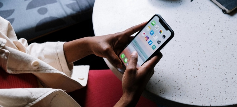 Woman browsing social media on a mobile device, highlighting digital services impacted by Canada’s digital services tax for movers.
