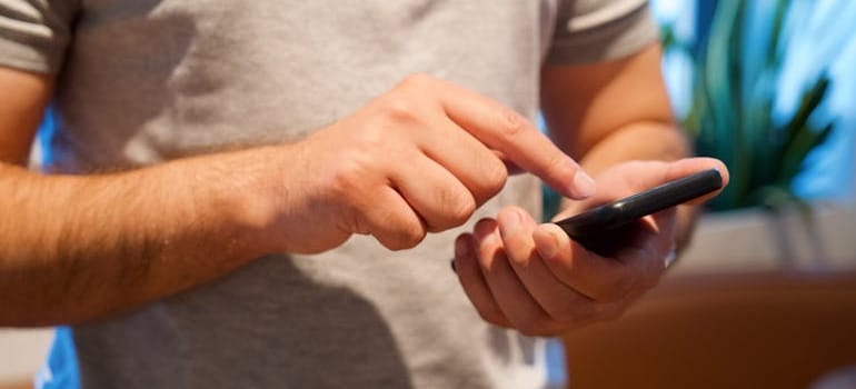 A person using their smartphone to search for moving companies
