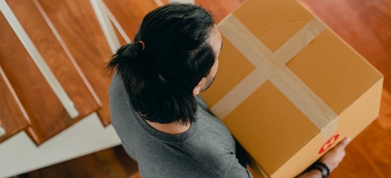 A person carrying a box while relocating with a company that knows how to generate social media leads using smart strategies
