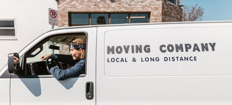 A person driving a van of a moving company that knows about the benefits of hiring a professional web developer