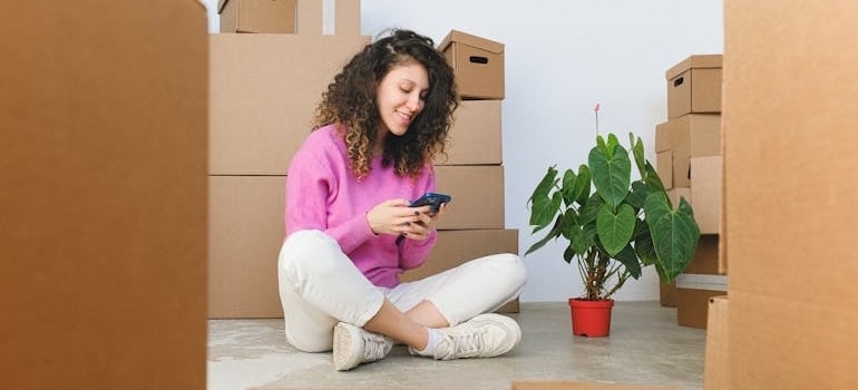 A person using a phone to leave a positive review, which is one of the best free lead sources for moving companies