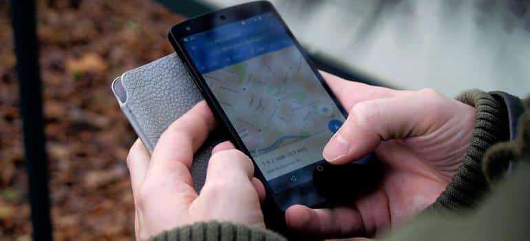 Person using mobile phone to search for nearby moving companies on a map