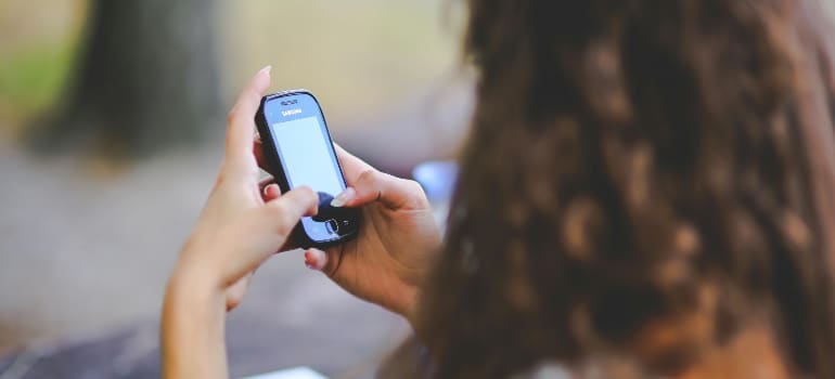 A woman receiving SMS from a moving company.