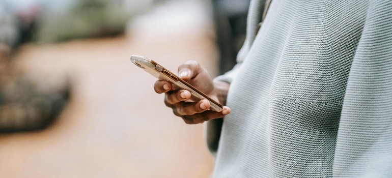A close-up of a person receiving SMS from a moving company, demonstrating the role of SMS marketing in closing moving leads with quick, personalized messages.