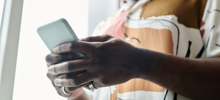 A person using a smartphone to look for moving company