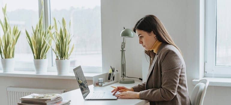 A company owner using a laptop to explore how to use Quora and Reddit to drive moving leads
