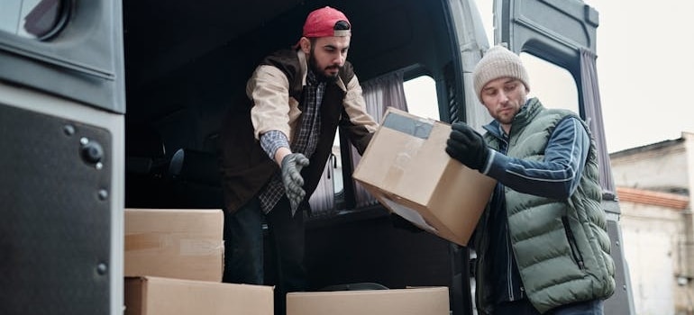 Movers taking boxes out of a van