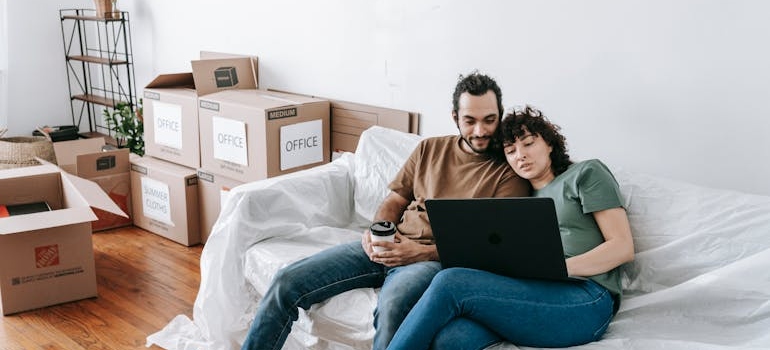 A couple using a laptop to google moving companies