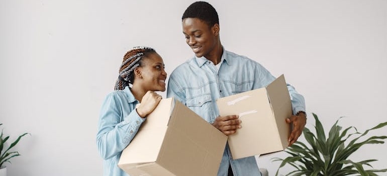 A happy couple holding boxes and preparing for a relocation