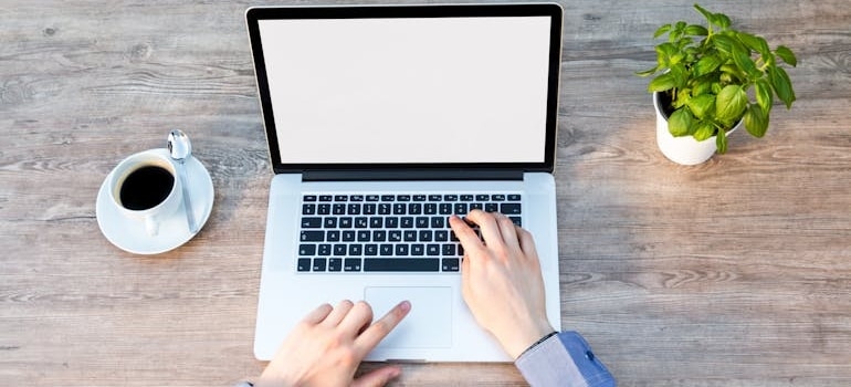 A peron using a laptop and working after learning what to consider when naming your moving business