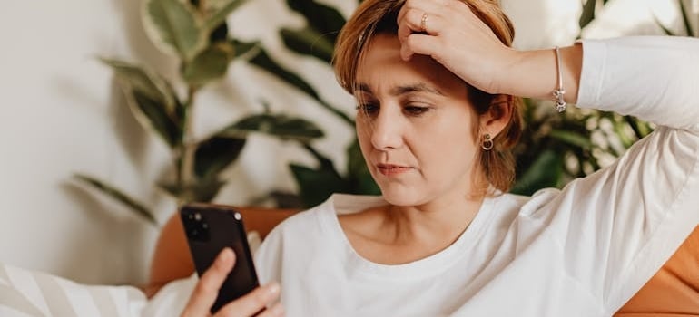 A using a smartphone to check services of a moving company