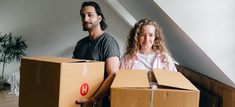 Two people holding boxes and preparing for a relocation
