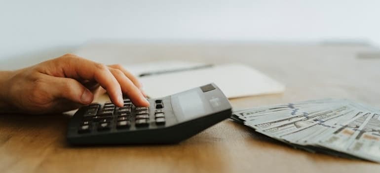A person using a calculator to answer the question: How much do moving leads cost?