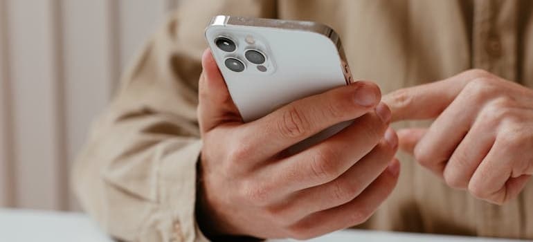 A person using a smartphone to look for moving companies