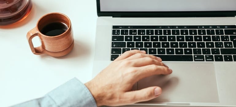 A person using a laptop to look for moving companies