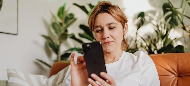 A person using a smartphone to explore the services of a moving company