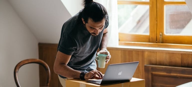 A person using a laptop to look for services of a moving company that benefits from new Google Ads features