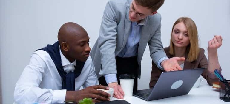 Three professionals discussing strategy during a business meeting, illustrating what happens to your leads when you stop paying for ads and visibility drops.
