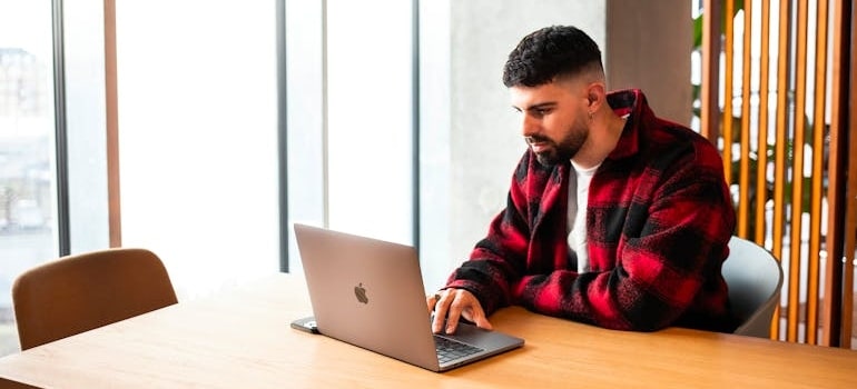 A person using a laptop to look for moving companies