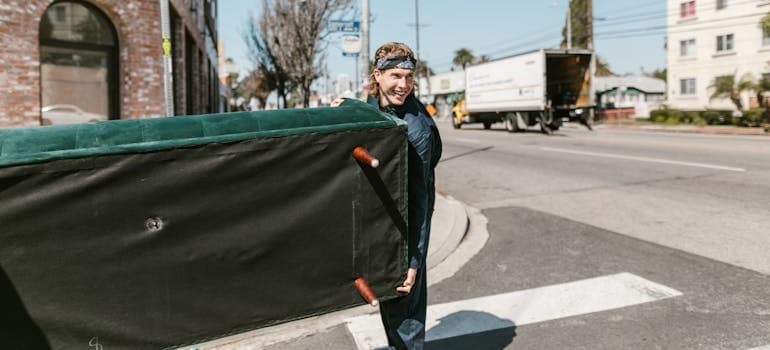 An employee of a moving company carrying a couch