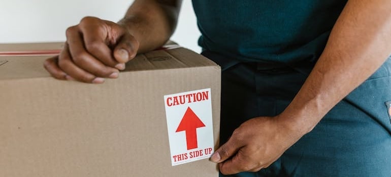 A moving company employee preparing a box for a relocation