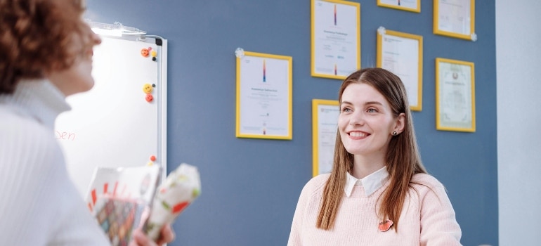 A person standing behind a wall filled with certifications.
