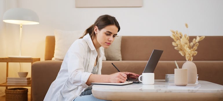 A person writing down prices and comparing different moving companies