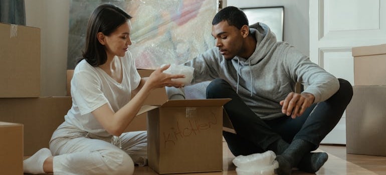 A couple putting items in a box and preparing for a move