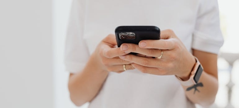A person using a smartphone to search for moving companies