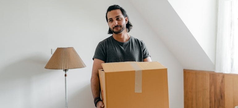 A person holding a box while preparing for a move