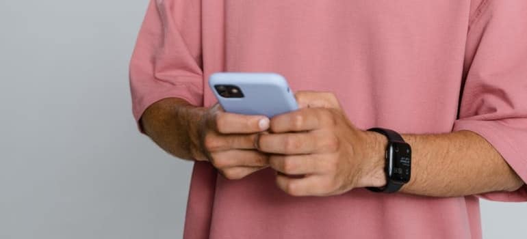 A person using a smartphone to look for and compare moving companies before deciding to call for pricing