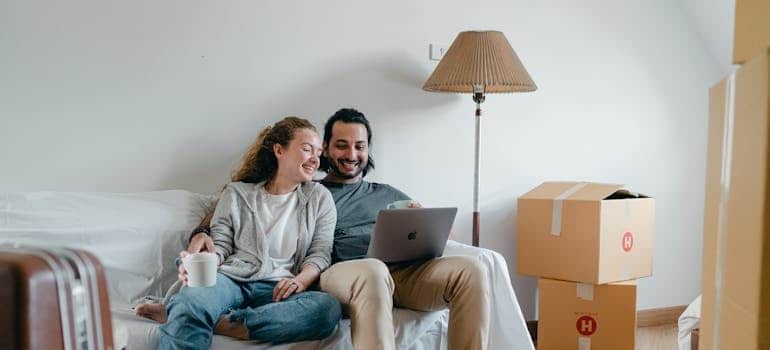 A couple using a laptop to search for moving companies