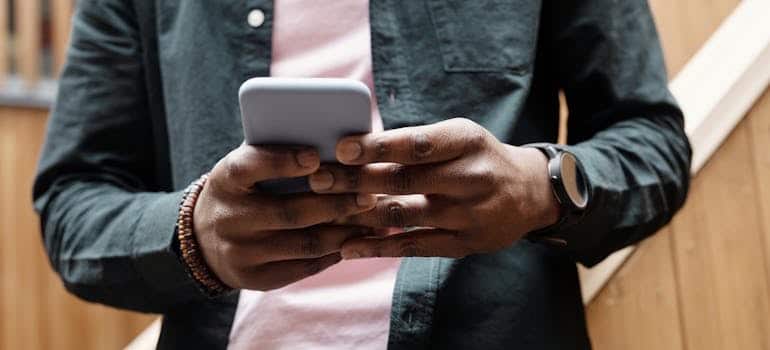 Person searching for moving companies on a smartphone