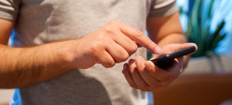 A person using a smartphone to look for moving companies online